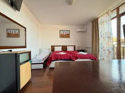 a bedroom with a bed with a red blanket at Family Hotel Carpe Diem in Banya