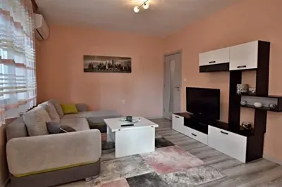 a living room with a couch and a tv at Апартамент Фреш in Velingrad