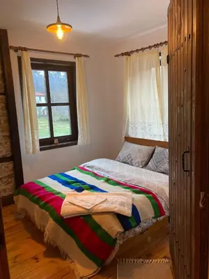 a bed in a bedroom with a window at Къща Александрова с басейн вътрешен и отопляем in Arda