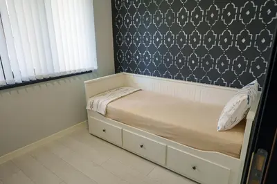 a small bed in a bedroom with a wall at Loft Apartment with a great view of Ardino in Ardino