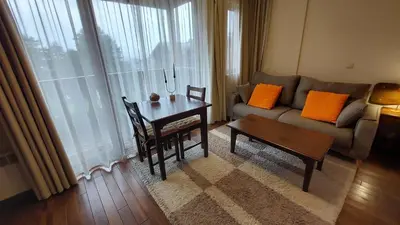 a living room with a couch and a table at Сладко студио в Пирин с голф и СПА комплекс in Razlog