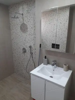 a bathroom with a sink and a shower with a mirror at Sandanski city center apartment in Sandanski
