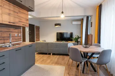 a kitchen with a table and chairs and a living room at Апартаменти 22 in Velingrad