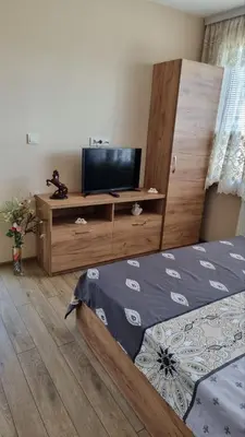 a bedroom with two beds and a flat screen tv at Родопска къща за гости с.ЧАЛА in Chala