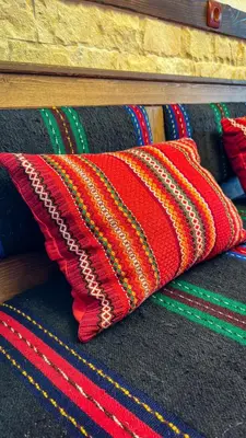 a red pillow sitting on top of a rug at Родопска къща за гости с.ЧАЛА in Chala