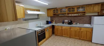 a kitchen with wooden cabinets and a white refrigerator at Къща за гости Релакс-Рaдуил in Raduil