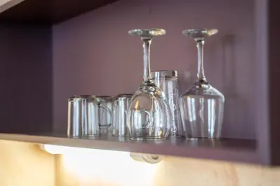 a shelf with wine glasses on top of it at Lovely apartment in Studentski grad in Sofia