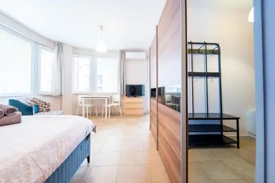 a bedroom with a bed and a dining room at Lovely apartment in Studentski grad in Sofia