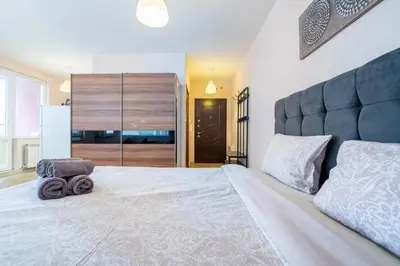 a bedroom with a large white bed with a large headboard at Lovely apartment in Studentski grad in Sofia