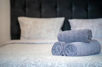 a pile of towels sitting on top of a bed at Lovely apartment in Studentski grad in Sofia