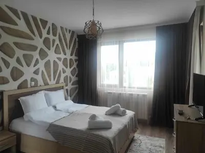 a bedroom with a bed with two towels on it at Апартамент Четири сезона 2 in Velingrad