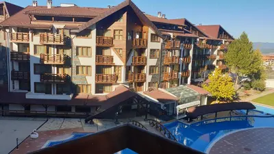 an apartment building with a pool in front of it at 500м. от лифта Сладък дом в Белведере СПА комплекс in Bansko