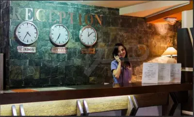 a woman talking on a cell phone next to clocks at 500м. от лифта Сладък дом в Белведере СПА комплекс in Bansko