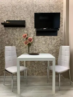 a white table with two chairs and a tv on a wall at Harmony Centrally Located Studio in Sofia
