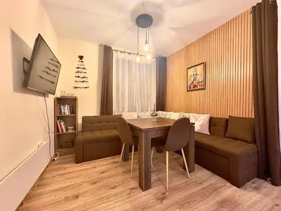 a living room with a table and a couch at Petkovi Аpartments, Borovets Gardens - One-bedroom and Two-bedroom apartments in Borovets