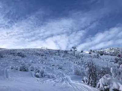 a snow covered hill with a ski lift at Petkovi Аpartments, Borovets Gardens - One-bedroom and Two-bedroom apartments in Borovets
