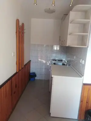 a small kitchen with white cabinets and a sink at Вила Родопи in Dospat