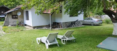 two chairs sitting in a yard next to a house at Вила Даяна in Ribarica