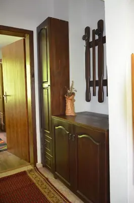 a kitchen with a cabinet and knives hanging on the wall at Вила Даяна in Ribarica