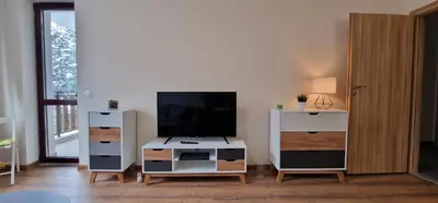 a living room with a tv and a white dresser at Pine Tree Apartment / Borovets Gardens in Borovets