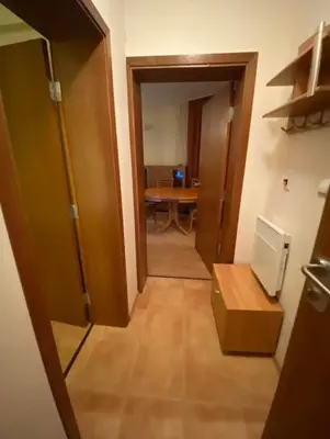 a hallway of a room with a table and a door at ЗАМЪКА 1 in Pamporovo