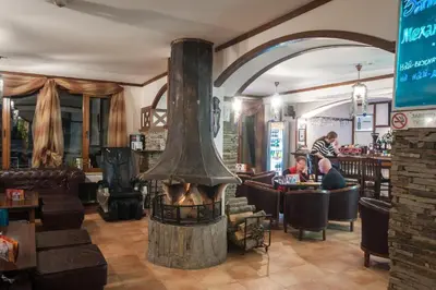 a restaurant with a fireplace in the middle of a room at ЗАМЪКА 1 in Pamporovo