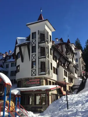 a large building in the snow next to a playground at ЗАМЪКА 1 in Pamporovo