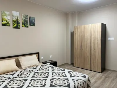 a bedroom with a bed and a wooden cabinet at Georgievi Apartments Sandanski in Sandanski