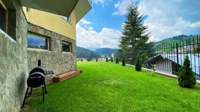 a house with a grill on the side of a yard at House Proctor in Stoykite