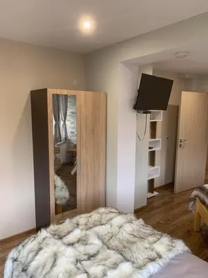 a bedroom with a bed and a mirror and a television at House Proctor in Stoykite