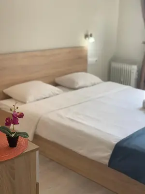 a bedroom with a large white bed and a table at City Residence Apartments Sofia in Sofia
