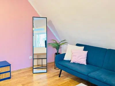 a blue couch in a room with a mirror at Minimalist Apartment in Sofia