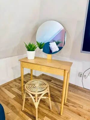 a wooden table with a mirror and a stool at Minimalist Apartment in Sofia