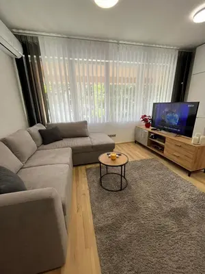 a living room with a couch and a flat screen tv at CityApartment in Sofia