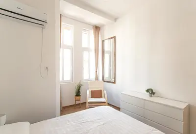 a white bedroom with a bed and a chair at Supreme Luxury Top Central 1 Bedroom Apartment in Sofia