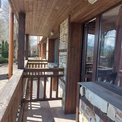 a porch of a building with benches and windows at Комплекс Александьр между Банско и село Бяня in Bansko