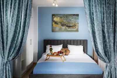 a bedroom with a bed with blue curtains and a table at Free Parking On Premises Huge Terrace in Sofia