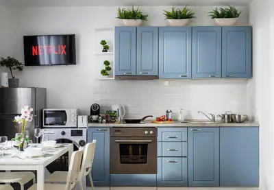 a kitchen with blue cabinets and a table with a dining room at Free Parking On Premises Huge Terrace in Sofia