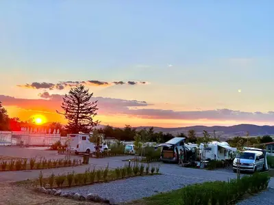 a group of rvs parked in a parking lot at sunset at 7 Lakes camping in Sapareva Banya