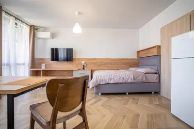 a bedroom with a bed and a table and a desk at Amarant Aparts in Sofia