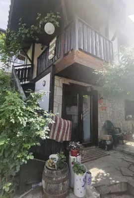 a house with a balcony and a porch with plants at Guest house Smolyan in Smolyan
