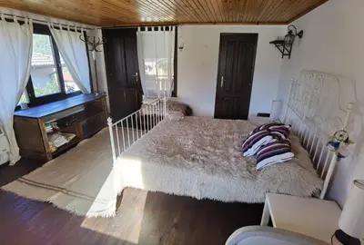 a bedroom with a large bed and a piano at Guest house Smolyan in Smolyan