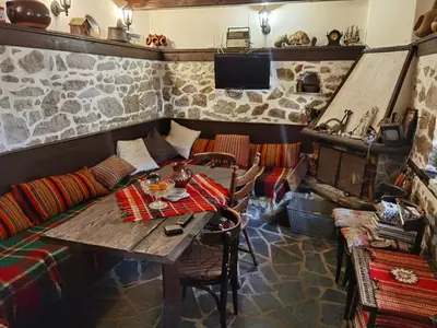 a room with a table and a couch at Guest house Smolyan in Smolyan