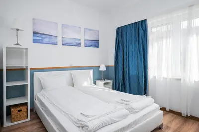 a bedroom with a white bed with blue curtains at Charming Studio on Vitosha Street by Flat Mаnager in Sofia