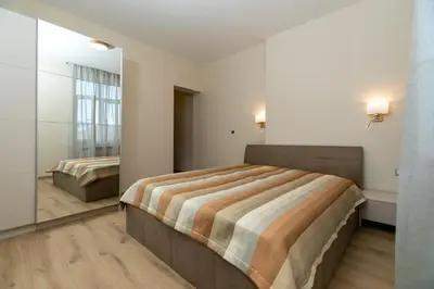 a bedroom with two beds and a mirror at Луксозни студия “Старият Батак” / Luxury studios “The Old Batak” in Batak