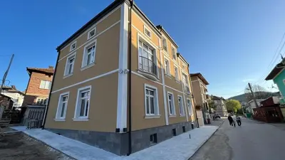 a brown and white building on the side of a street at Луксозни студия “Старият Батак” / Luxury studios “The Old Batak” in Batak