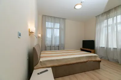 a bedroom with a bed and a flat screen tv at Луксозни студия “Старият Батак” / Luxury studios “The Old Batak” in Batak