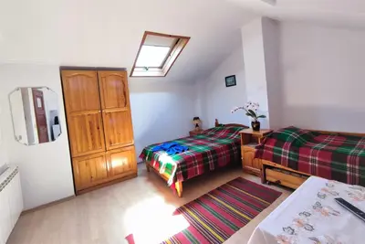 a bedroom with two beds and a dresser and a window at Къща Чолаков и син - стаи за гости in Devin
