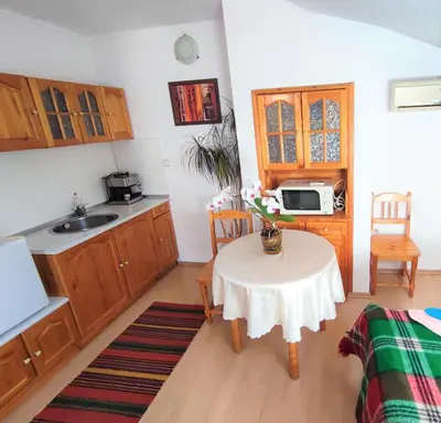 a kitchen with a table and a small kitchen with a sink at Къща Чолаков и син - стаи за гости in Devin