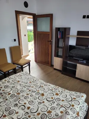 a bedroom with a bed and a flat screen tv at Къща Чолаков и син - стаи за гости in Devin
